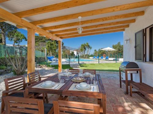 a wooden table and chairs on a patio at Carvoeiro Peaceful Villa with Pool in Carvoeiro