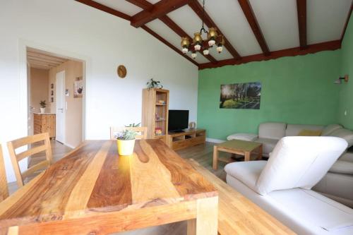 - un salon avec une table en bois et un canapé dans l'établissement Ferienwohnung Steinberg mit Sauna, à Wernesgrün