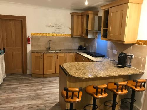 a kitchen with wooden cabinets and a island with bar stools at Citretum Angulus in Southampton