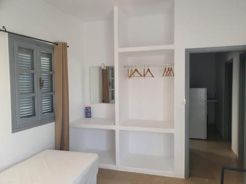 a room with white shelves and a bed in it at Teoria Paros - Matsas Windmill in Naousa