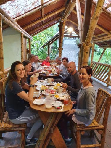 grupa ludzi siedzących przy stole jedzących jedzenie w obiekcie Finca Las Palmas Ecolodge w mieście Puyo