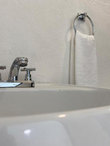 a bathroom with a white sink and a towel at Casa Colibrí El Cuyo in El Cuyo