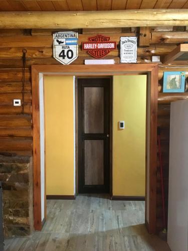 a room with a yellow door and signs on the wall at Cabaña LA EMILIA Uspallata Mdz in Uspallata
