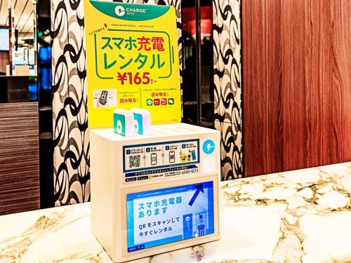 a sign on top of a machine on a counter at APA Hotel Ginza Kyobashi Tokyo Eki Yaesu Minamiguchi in Tokyo