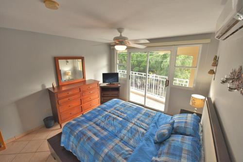 a bedroom with a bed and a dresser and a window at Seashore Condo in Rincon