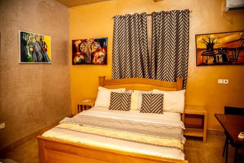 a bedroom with a bed with two pillows and a window at Homey Lodge in Kumasi