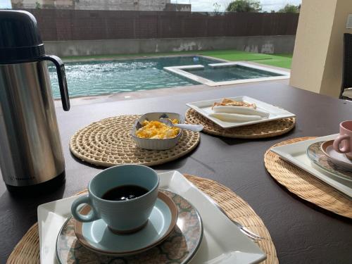 a table with plates of food and a cup of coffee at Espetacular Casa de Charme em São Miguel do Gostoso - Salou in São Miguel do Gostoso