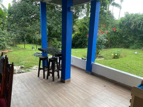 a porch with a black table and chairs and a dog at Finca la vaga in Filandia