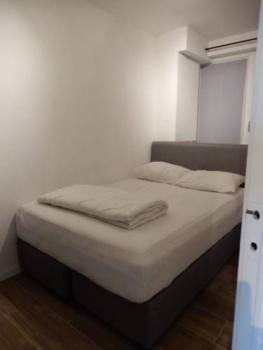 a bed with two pillows on it in a room at Gelijkvloers zeezicht appartement Sterckx in Blankenberge