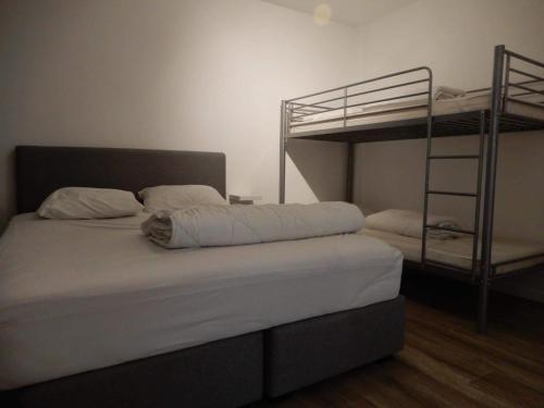 a bedroom with two bunk beds and a ladder at Gelijkvloers zeezicht appartement Sterckx in Blankenberge