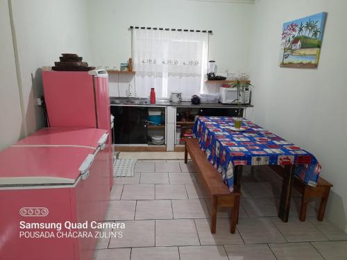 um quarto com uma mesa e uma cozinha com um balcão em Casa Chácara Zulin's,-SIMPLICIDADE E AMOR em Pontal do Paraná