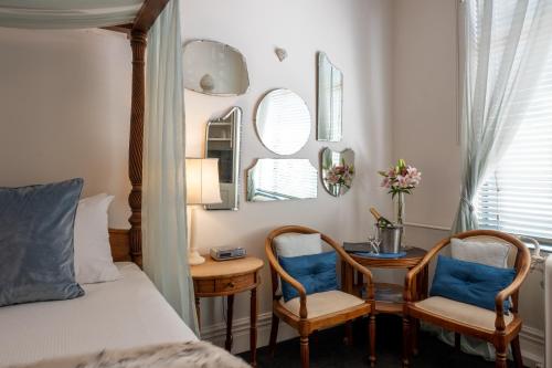 a bedroom with a bed and a table and chairs at Hotel D'urville Blenheim in Blenheim