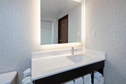 a bathroom with a white sink and a mirror at Holiday Inn Express & Suites Oakland - Airport by IHG in Oakland