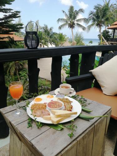 a breakfast of eggs and toast on a table on a balcony at RED PEARL BEACH RESORT in Chaloklum