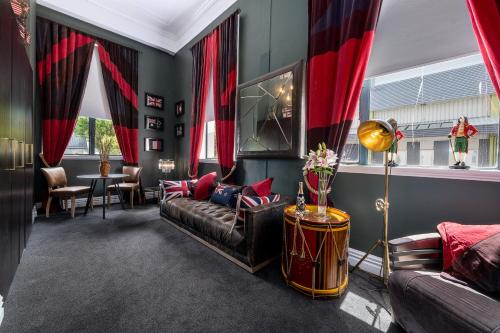 a living room with red curtains and a couch at Hotel D'urville Blenheim in Blenheim