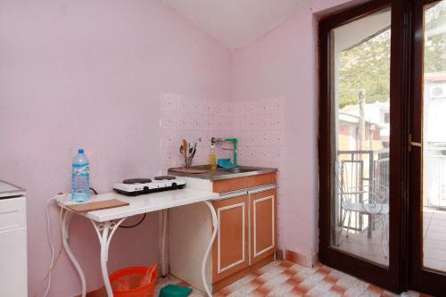 波达卡Rooms with a parking space Podaca, Makarska - 517的厨房配有白色的柜台和桌子