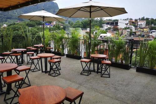 a group of tables and chairs with umbrellas on a patio at Artesanos 11 in Tepoztlán