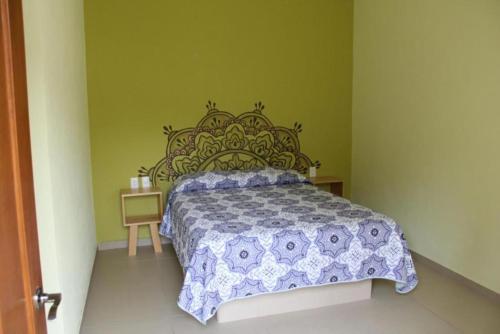 1 dormitorio con 1 cama con colcha azul y blanca en Artesanos 11 by Rotamundos en Tepoztlán