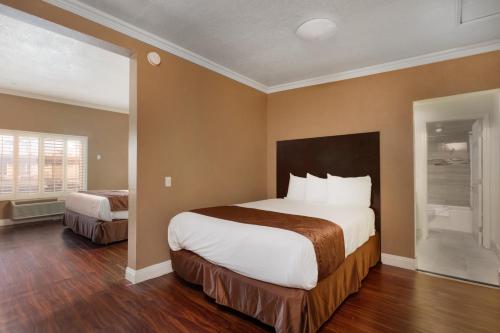 a hotel room with a large bed and a window at Americas Best Value Inn & Suites Anaheim in Anaheim