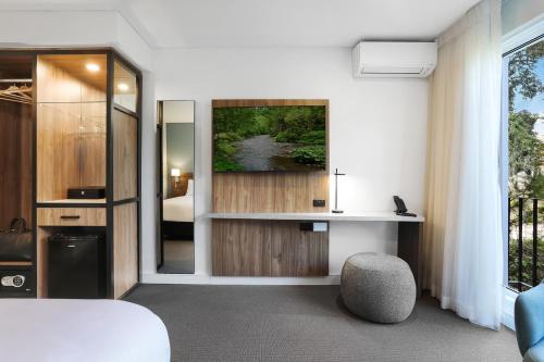 a room with a bed and a desk and a window at Killara Hotel & Suites in Killara