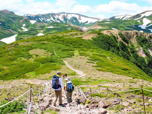 two people standing on a mountain taking a picture at Sounkyo Hostel in Kamikawa