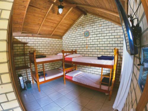 a small room with four bunk beds in it at Haleakala Hostel & Pousada in Praia do Rosa