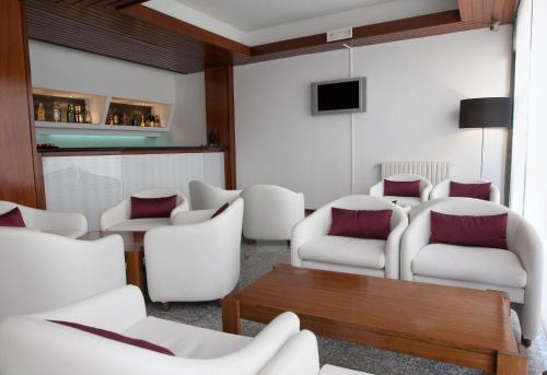 a waiting room with white chairs and a table at Hotel Costa de Prata 2 & Spa in Figueira da Foz