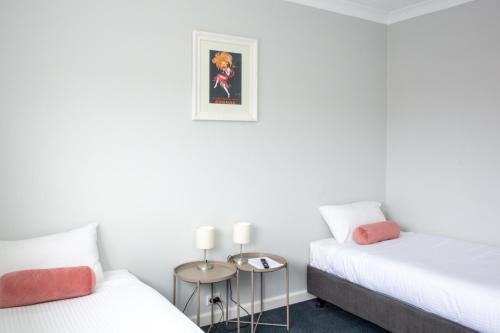 two beds in a room with white walls at Five Island Hotel in Cringila