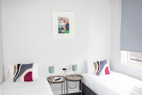 two beds in a room with white walls at Five Island Hotel in Cringila