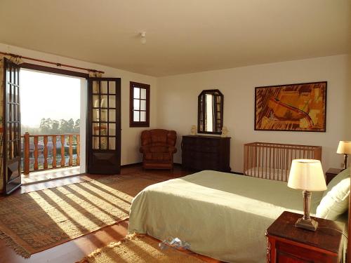 a bedroom with a bed and a balcony at LIMA COTTAGES - Casa de S Tiago in Ponte de Lima