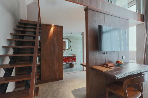 a room with a staircase and a table and a television at CHERRY BOUTIQUE HOTEL in Ho Chi Minh City
