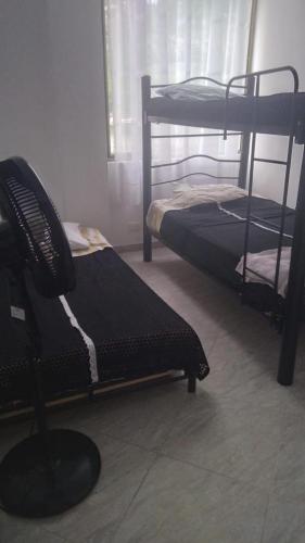 a room with two bunk beds and a chair at Casa en conjunto campestre, rana y bolirrana incluido. in Apulo