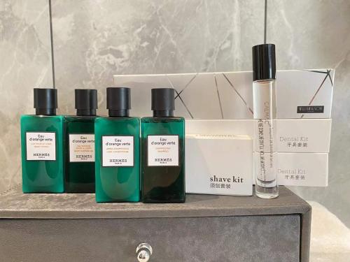 a group of three bottles of perfume on a shelf at Qingdao Treasure Hotel in Qingdao