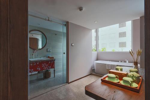 a bathroom with a tub and a sink and a mirror at CHERRY BOUTIQUE HOTEL in Ho Chi Minh City