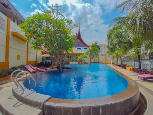 a swimming pool in front of a building with a resort at Truntum Padang in Padang