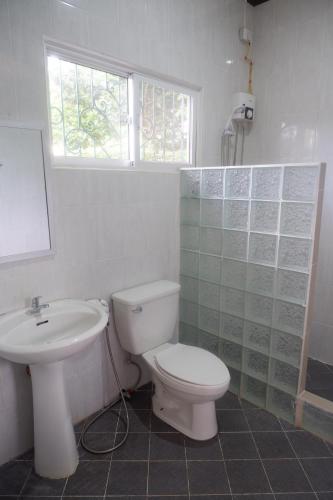 a bathroom with a toilet and a sink and a window at Villa Camotes in Camotes Islands
