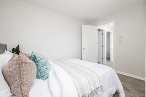 a white bedroom with a white bed with pillows at Beautiful 3 bedroom Condo in Hartford! in Hartford