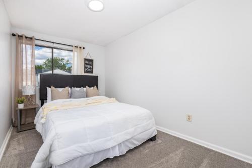 a white bedroom with a large bed and a window at Beautiful 3 bedroom Condo in Hartford! in Hartford