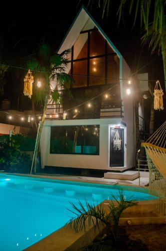a house with a swimming pool at night at Xtambaa Cabins & Spa Only Adults in El Cuyo