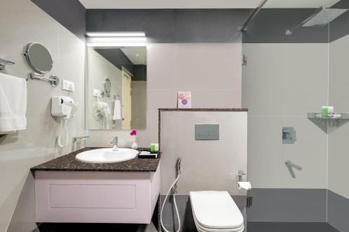 a bathroom with a sink and a toilet and a shower at Lemongrass inn munnar in Anachal