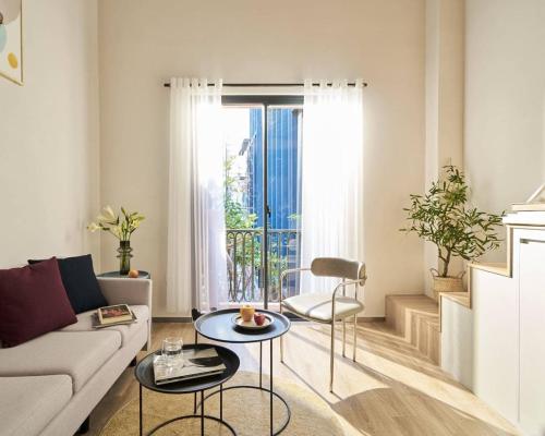 a living room with a couch and two tables at M Village Living Võ Thị Sáu in Ho Chi Minh City