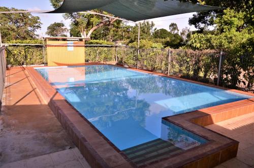 a swimming pool in a backyard with a fence at Affordable Gold City Motel in Charters Towers