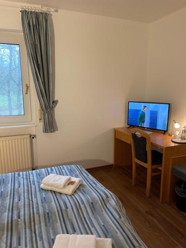 a bedroom with a bed and a desk with a computer at Hotel Luther Birke Wittenberg in Lutherstadt Wittenberg