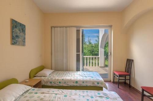 1 Schlafzimmer mit 2 Betten und einem Fenster mit Balkon in der Unterkunft Apartments Blue Skies - 30 m from the sea in Ljubač