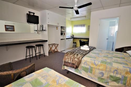 A bed or beds in a room at Affordable Gold City Motel