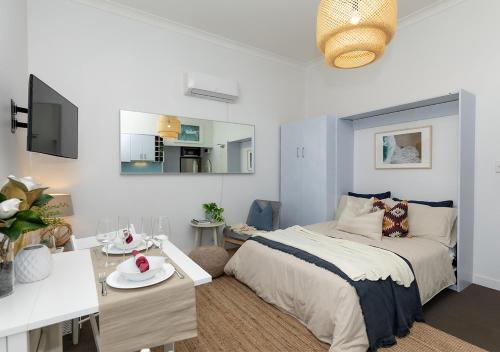 a bedroom with a bed and a dining room at COZY BEACH FRONT STUDIO WITH AIRCON in Sydney