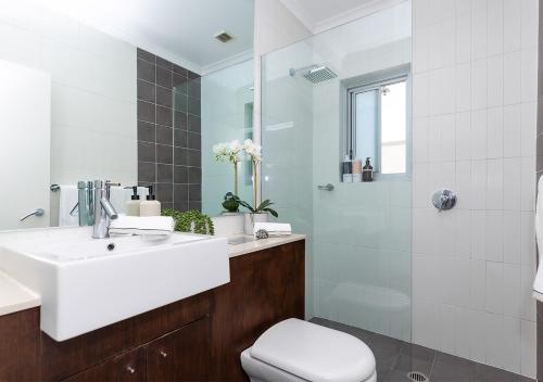 a bathroom with a sink and a toilet and a shower at COZY BEACH FRONT STUDIO WITH AIRCON in Sydney