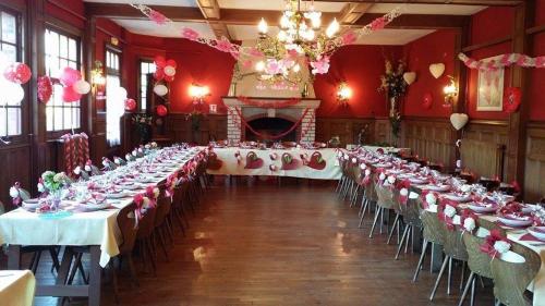 a banquet hall with tables with white and pink decorations at Hotellerie Normande in Dozulé