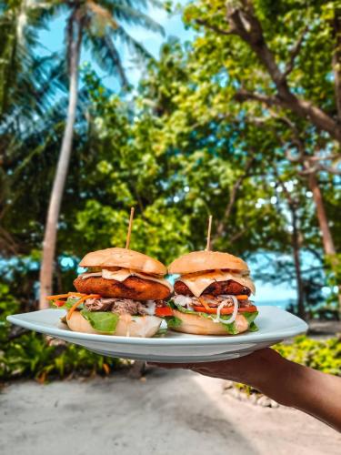 a person holding a plate with a sandwich on it at Thundi Sea View in Fulidhoo