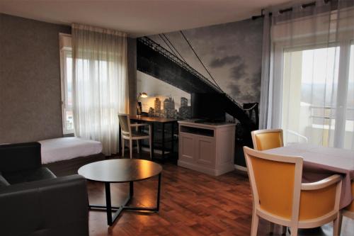 uma sala de estar com uma cama e uma sala de jantar em Résidence Carouge Appart Hôtel em Brétigny-sur-Orge